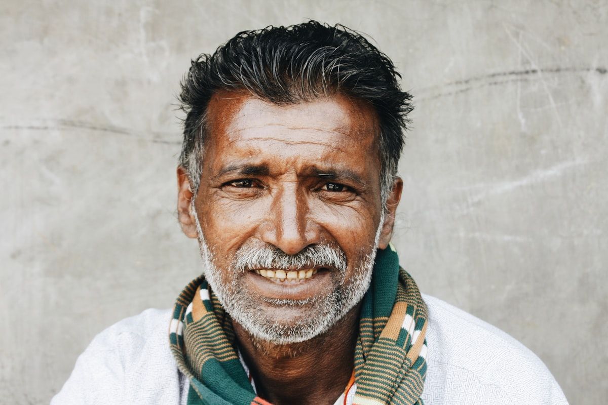 An older man smiling, supported and engaged